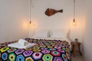 a bedroom with a bed with a colorful blanket at Hillside 1 Aljezur old town in Aljezur