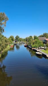 einen Fluss mit Booten, die seitlich geparkt sind in der Unterkunft Ferienhaus Femke in Emden