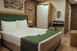 a bedroom with a large bed and a mirror at HASUNİ TAŞ HOTEL in Diyarbakır
