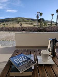 a book and a cup of coffee on a wooden table at Apartamentos MadreSelva in Fernán Pérez