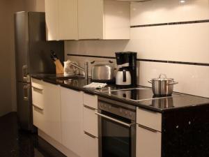 a kitchen with white cabinets and a stove top oven at Apartment in the water tower, Güstrow in Güstrow
