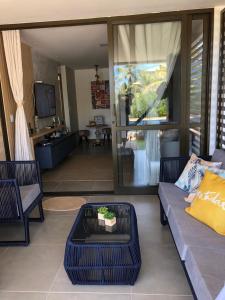 a living room with a couch and a table at Pé na areia Itacimirim in Camacari
