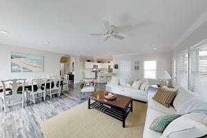 a living room with a white couch and a table at Shady Retreat in Tybee Island