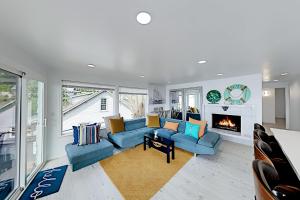a living room with blue couches and a fireplace at Beach House Oasis in Des Moines