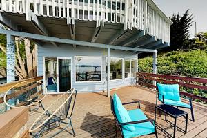 a patio with two chairs and a deck with a balcony at Beach House Oasis in Des Moines