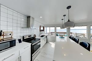 a kitchen with white appliances and a view of the ocean at Beach House Oasis in Des Moines