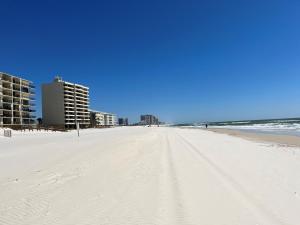 a white beach with some buildings and the ocean at Ole River Hideway, Orange Beach, Updated 2 Bedroom Waterfront Condo, Wind Drift in Orange Beach