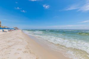 a beach with people on it and the ocean at Ole River Hideway, Orange Beach, Updated 2 Bedroom Waterfront Condo, Wind Drift in Orange Beach