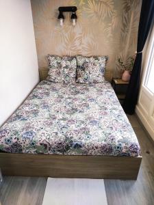 a bed in a bedroom with a floral bedspread at 36 Dajot Boutique Apartment - 70 in Melun