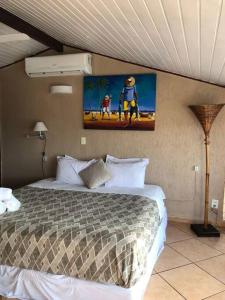 1 dormitorio con 1 cama y una pintura en la pared en Apartamento Rua das Pedras Vista mar, en Búzios