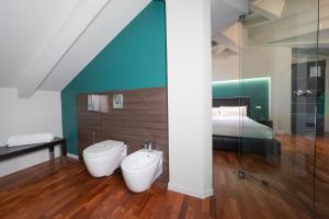 a bathroom with a toilet and a bed at SIRIOHotel in Dormelletto