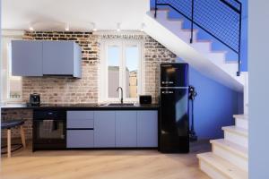 een keuken met een zwarte koelkast en een trap bij Vailato Loft Suites in Corfu-stad