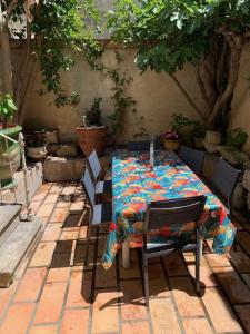 uma mesa e cadeiras com uma toalha de mesa em La maison sur la place em Aigues-Mortes