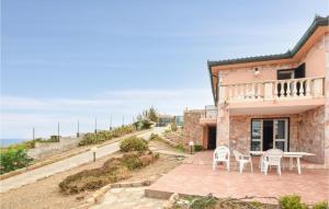 een huis met een balkon en een tafel en stoelen bij Beautiful Apartment In La Ciaccia With House Sea View in Codaruina