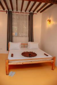 A bed or beds in a room at Jambiani Guest Lodge UNGUJA