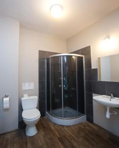 a bathroom with a shower and a toilet and a sink at Corner Hostel in Wrocław