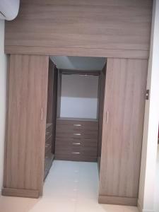 a walk in closet with wooden cabinets and a window at Hospedaje bolognesi in Piura