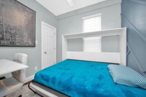 a bedroom with a blue bed in a white room at Modern 2 Bedroom in Avondale in Chicago