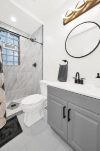 Modern 2 Bedroom in Avondale في شيكاغو: حمام مع مرحاض ومغسلة ومرآة