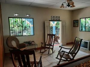 a living room with chairs and a table and windows at Ometepe House in Moyogalpa