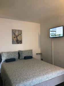 Schlafzimmer mit einem Bett und einem Flachbild-TV in der Unterkunft Amendola HOWME in Bari
