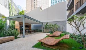 a patio with two wooden benches in front of a building at Is Liberdade in São Paulo