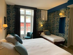 a hotel room with two beds and a window at Hôtel de Bretagne Dol centre ville - Hotel et Restaurant in Dol-de-Bretagne