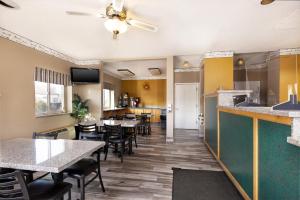 um restaurante com mesas e cadeiras e um bar em Bardmoor Suites em Cedar City