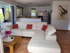 a living room with a white couch and a table at VILLA STE MARTHE avec piscine, grande terrasse, jardin intime et citerne d'eau in Saint-François