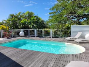 - une piscine au-dessus d'une terrasse avec des chaises et des soins dans l'établissement Villa Ste Marthe, à Saint-François