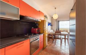 una cucina con armadi arancioni e una sala da pranzo di Stunning Apartment In Arbus With 2 Bedrooms ad Arbus