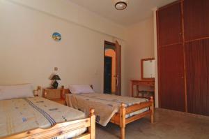 a bedroom with two beds and a closet at Haroula Apartments in Sidari