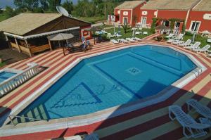 a large swimming pool on a deck next to a house at Haroula Apartments in Sidari