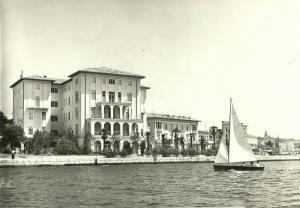 a small sail boat in the water in front of a building at BO Hotel Palazzo in Poreč