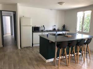 La cuisine est équipée d'un comptoir, d'un évier et d'un réfrigérateur. dans l'établissement Maison au calme avec parking en petite Camargue, à Beauvoisin