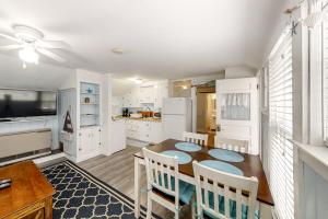 a kitchen with a table and chairs and a kitchen with white cabinets at Old Orchard Cottage in Old Orchard Beach