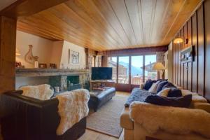 韋爾比耶的住宿－Ski-in, Chalet-style appt - 1 Min Walk to Lift，带沙发和壁炉的客厅