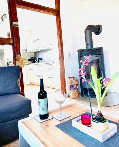 a table with a bottle of wine and a glass at Schöne ruhige Ferienwohnung - in Eisenach mit Kamin - Nahe Karolinentalbrücke - Hund ja in Eisenach