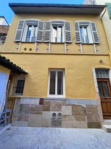 uma casa amarela com janelas fechadas numa rua em Le Sweet Forville 2 - Palais des Festivals - Marché provençal - Plage - Clim - Au calme em Cannes