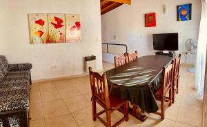 a dining room with a table and a tv at Las Hortensias in Junín