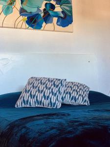una almohada sentada encima de una cama debajo de un cuadro en Las Hortensias en Junín