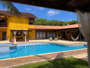 a swimming pool in front of a house at Jardim Boêmio in Cananéia