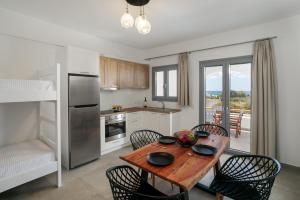 a kitchen with a wooden table with chairs and a dining room at Blue Gem in Kastraki