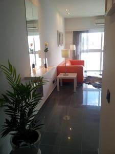 a living room with a red couch and a potted plant at Apartamento Rocamar - Albufeira in Albufeira