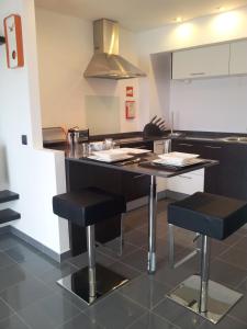 a kitchen with a table and stools in a kitchen at Apartamento Rocamar - Albufeira in Albufeira