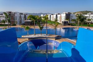 a large swimming pool with palm trees and buildings at Four Seasons Life Rentals in Trikomo
