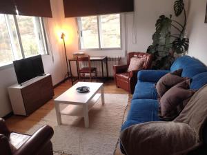sala de estar con sofá azul y mesa en Casa Loureira -Cabo do Mundo, Ribeira Sacra, en Rosende