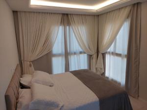 ein Schlafzimmer mit einem Bett vor einem Fenster in der Unterkunft Lindo Apartamento no Muro Alto Condomínio Clube in Ipojuca + 11 Fotos