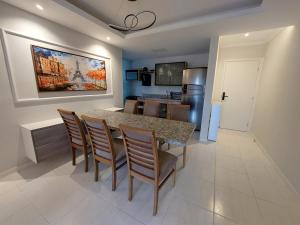 eine Küche und ein Esszimmer mit Tisch und Stühlen in der Unterkunft Lindo Apartamento no Muro Alto Condomínio Clube in Ipojuca