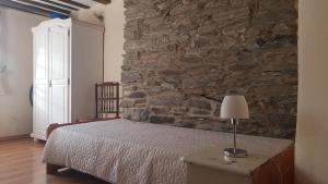 Un dormitorio con una cama y una pared de piedra. en Historisches Haus im Herzen von Monschau, en Monschau